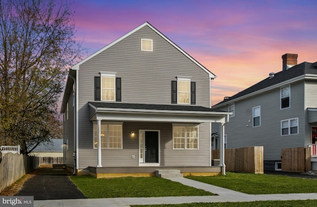 front of property with a lawn and covered porch