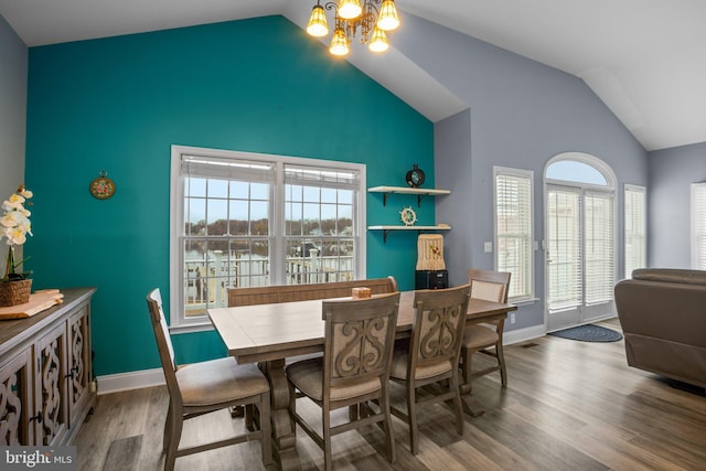 dining area featuring hardwood / wood-style flooring, a notable chandelier, and lofted ceiling