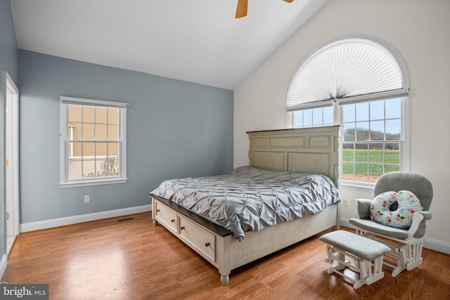 bedroom with ceiling fan, light hardwood / wood-style flooring, and lofted ceiling