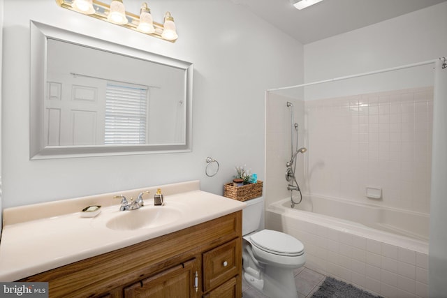 full bathroom featuring tiled shower / bath, tile patterned flooring, vanity, and toilet