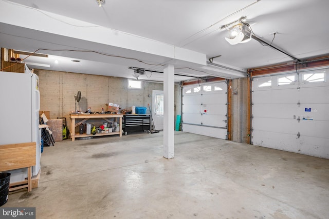 garage featuring white fridge and a garage door opener