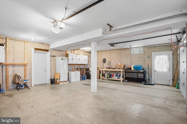 garage featuring white fridge and a garage door opener