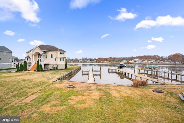 view of dock with a lawn and a water view