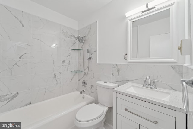 full bathroom with vanity, tiled shower / bath combo, tile walls, and toilet