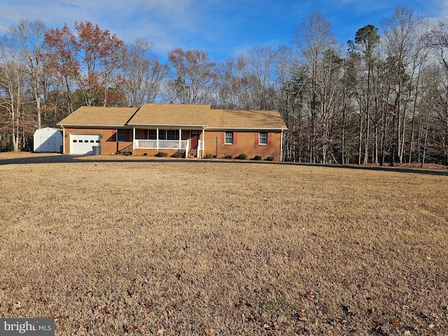 ranch-style home with a garage, covered porch, and a front lawn