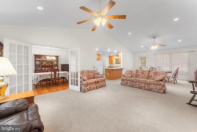 living room with french doors, carpet, ceiling fan with notable chandelier, and high vaulted ceiling