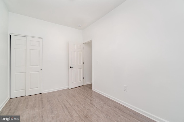 unfurnished bedroom with light hardwood / wood-style floors and a closet