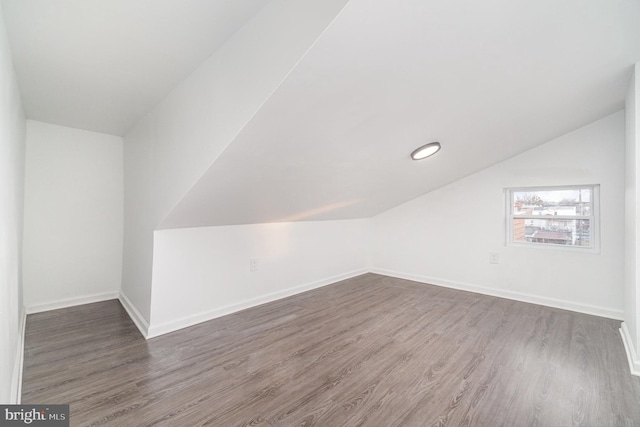 bonus room with dark hardwood / wood-style flooring and lofted ceiling