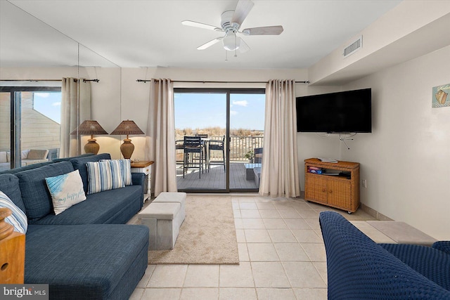 tiled living room featuring ceiling fan and a healthy amount of sunlight