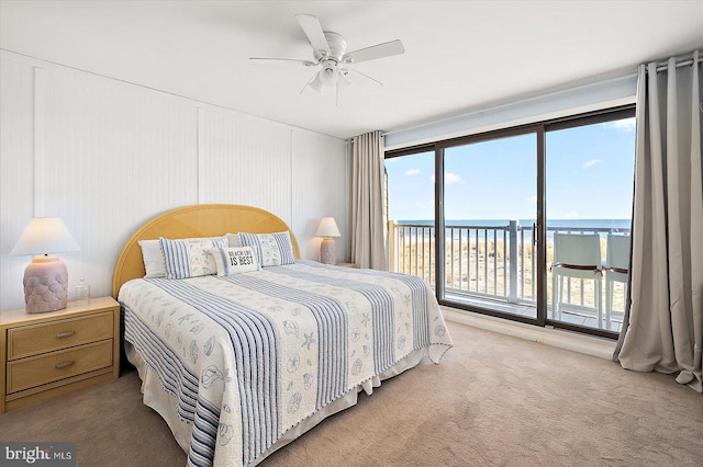 carpeted bedroom with a water view and ceiling fan