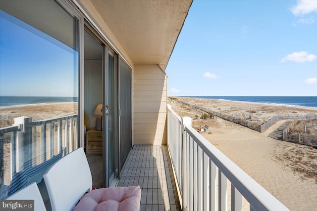 balcony featuring a beach view and a water view