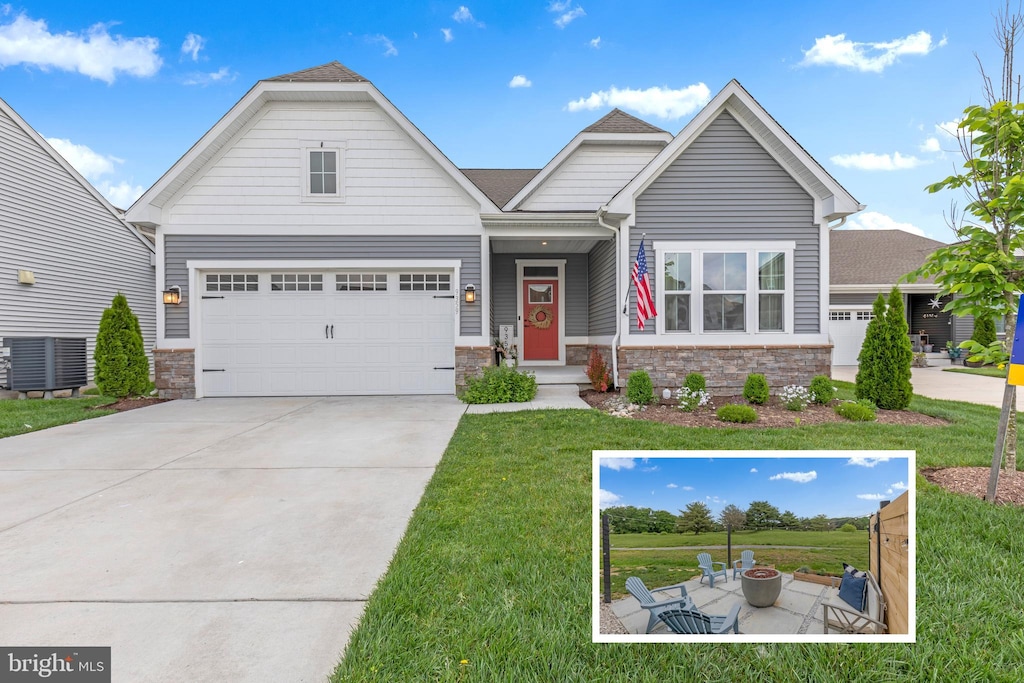 craftsman inspired home with central AC unit, a garage, and a front lawn