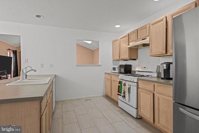 kitchen with light brown cabinets, white appliances, and sink