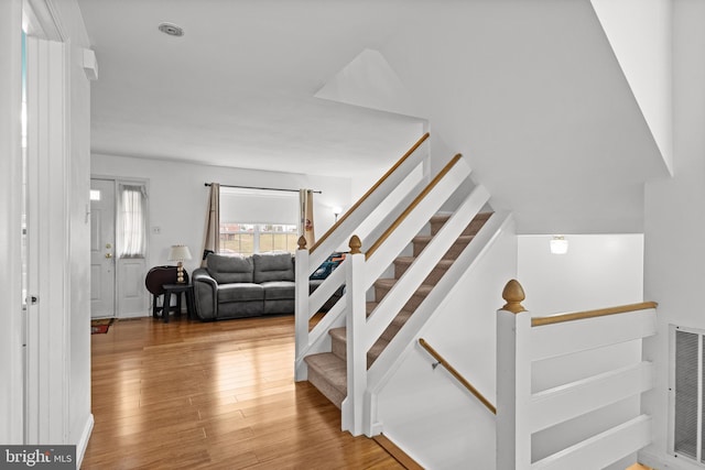 stairs featuring hardwood / wood-style floors