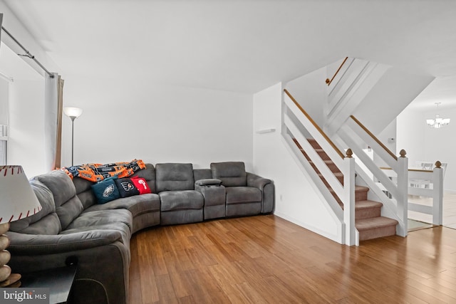 living room featuring wood-type flooring and an inviting chandelier