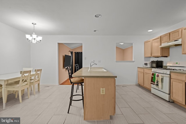 kitchen featuring sink, an inviting chandelier, an island with sink, decorative light fixtures, and white appliances