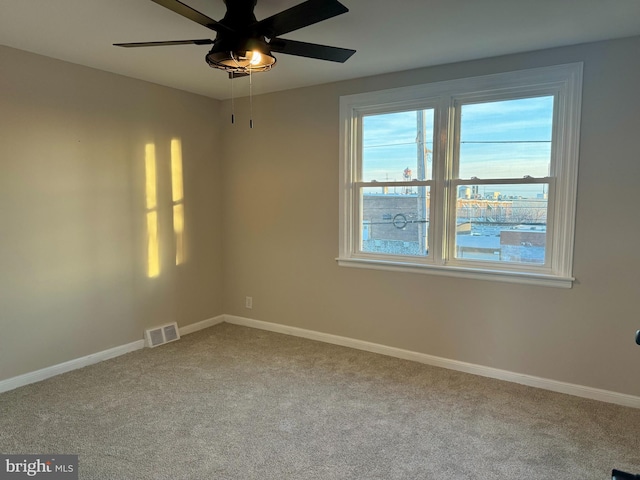 carpeted spare room featuring ceiling fan