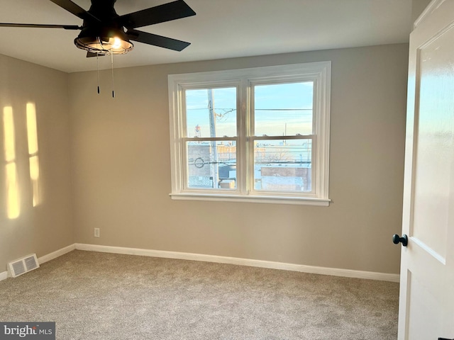 spare room featuring light carpet and ceiling fan