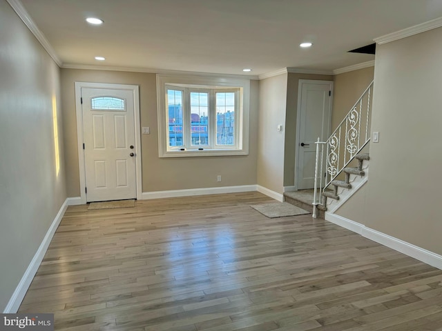 entryway with light wood-type flooring and ornamental molding