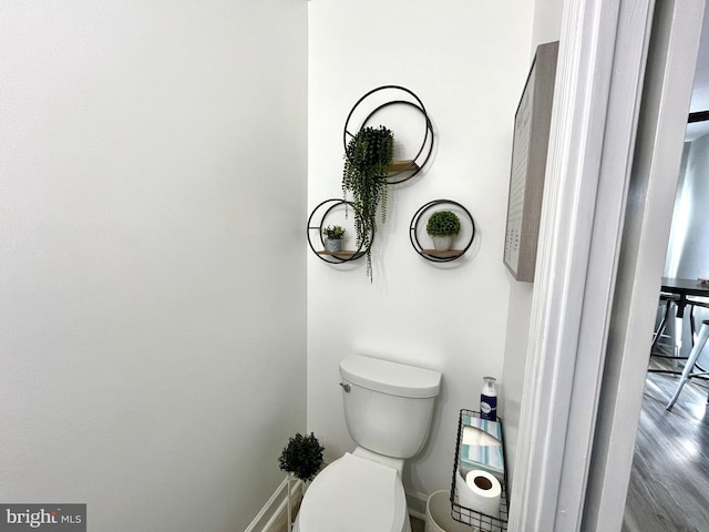 bathroom featuring hardwood / wood-style flooring and toilet