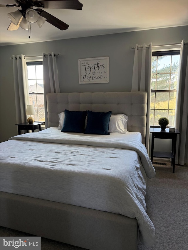 bedroom with carpet flooring, multiple windows, and ceiling fan