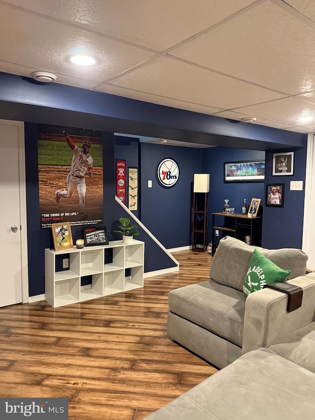 living room with a paneled ceiling and wood-type flooring