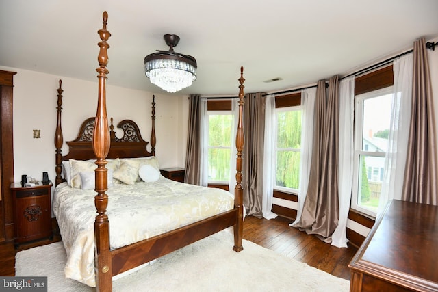 bedroom featuring dark hardwood / wood-style floors and an inviting chandelier