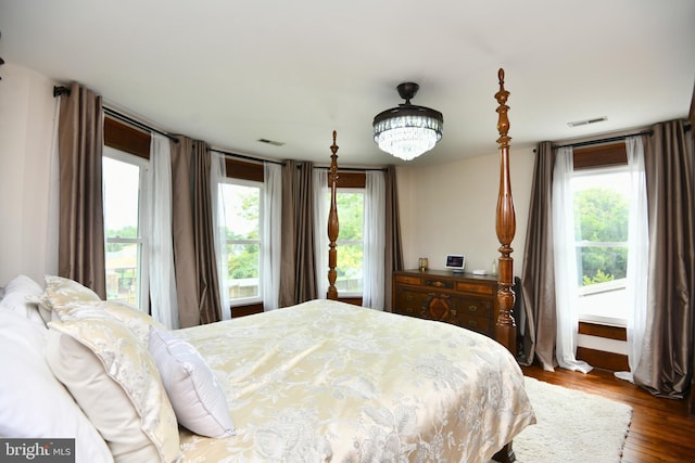 bedroom with hardwood / wood-style floors and multiple windows