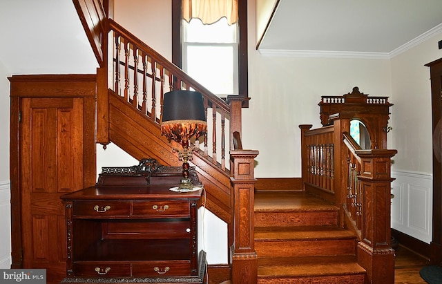 stairs featuring hardwood / wood-style floors and ornamental molding