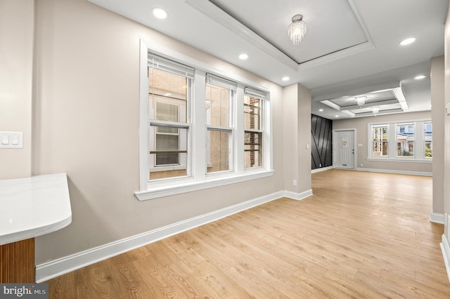 interior space featuring a tray ceiling, light hardwood / wood-style flooring, and a notable chandelier