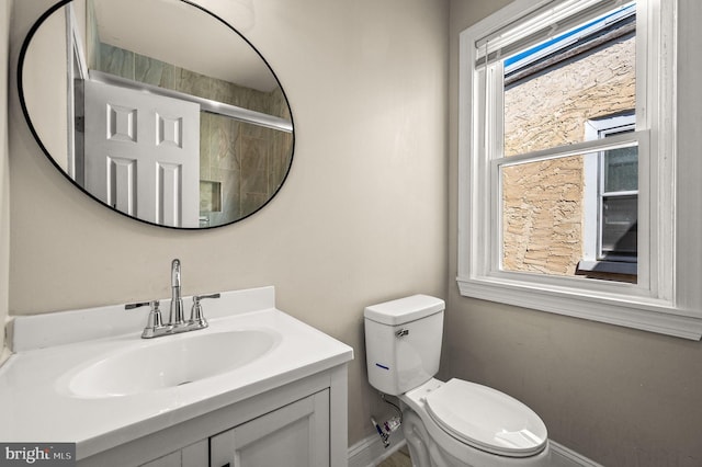 bathroom featuring vanity, toilet, and a shower