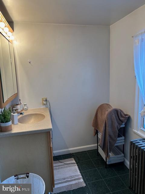 bathroom with tile patterned floors, vanity, and radiator