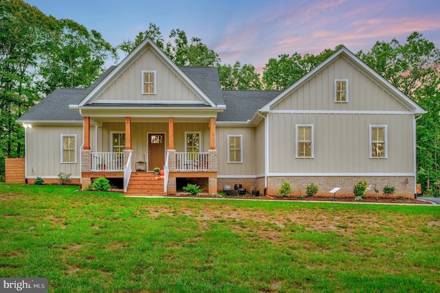 view of front facade with covered porch and a lawn