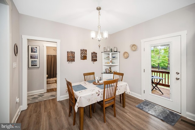 dining space with a chandelier and dark hardwood / wood-style floors