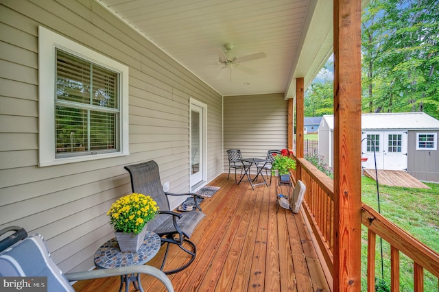 wooden terrace with ceiling fan and an outbuilding