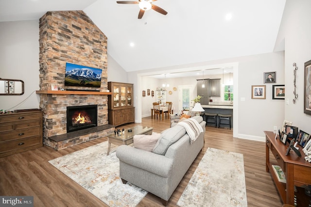 living room featuring ceiling fan, wood-type flooring, a fireplace, and high vaulted ceiling