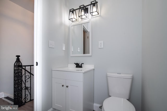 bathroom with hardwood / wood-style floors, vanity, and toilet