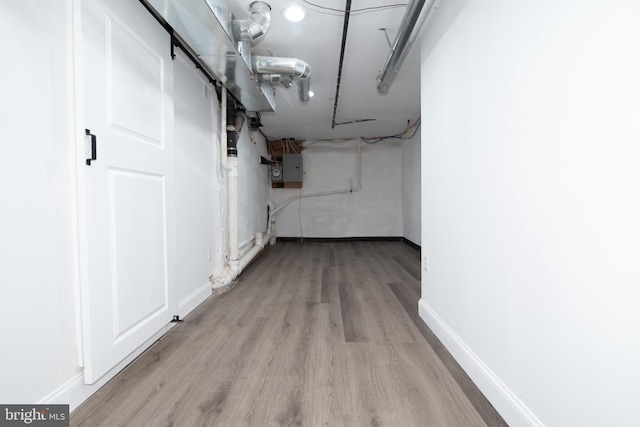 basement with electric panel and light hardwood / wood-style floors