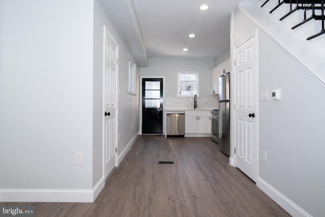 hall featuring wood-type flooring and sink