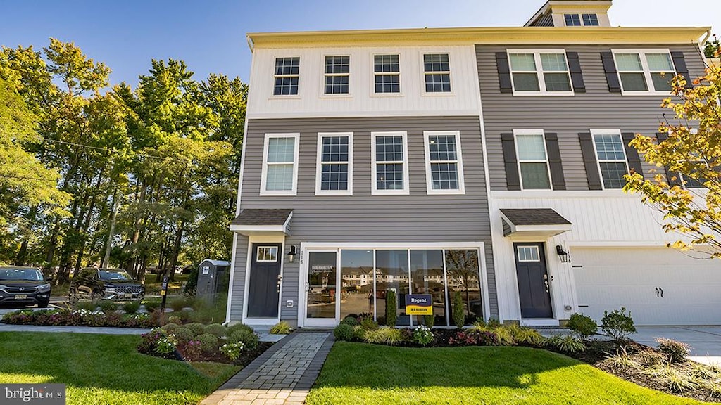 view of front of property featuring a front yard and a garage