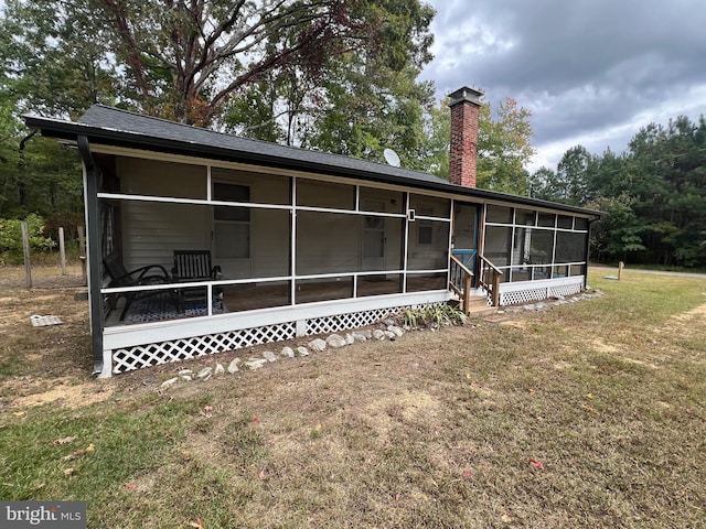 back of house with a yard and a sunroom