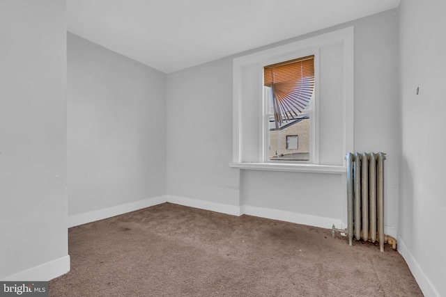 spare room featuring carpet flooring and radiator