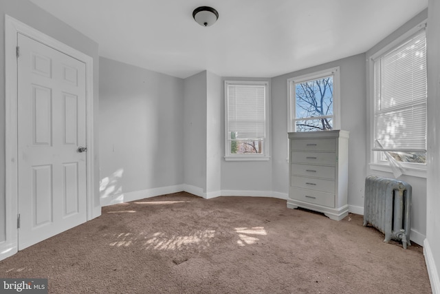 unfurnished bedroom with carpet flooring and radiator