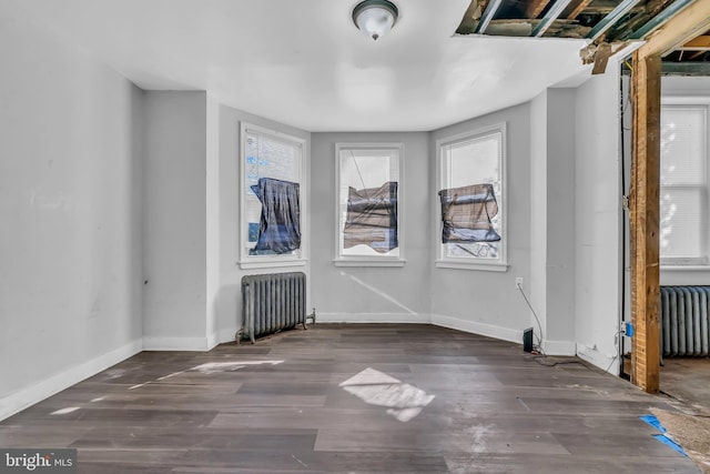 spare room featuring radiator and dark wood-type flooring