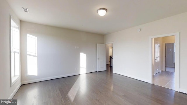 unfurnished room with dark wood-type flooring