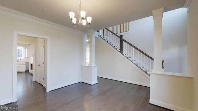 interior space with an inviting chandelier, ornamental molding, hardwood / wood-style floors, and ornate columns