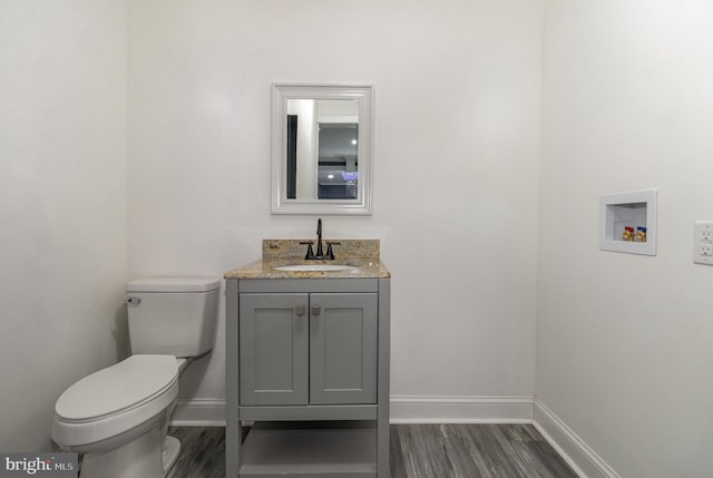 bathroom with vanity, hardwood / wood-style flooring, and toilet