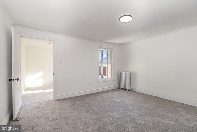 carpeted spare room featuring radiator heating unit and ornamental molding