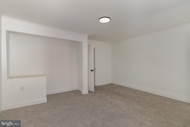 basement featuring light carpet and crown molding