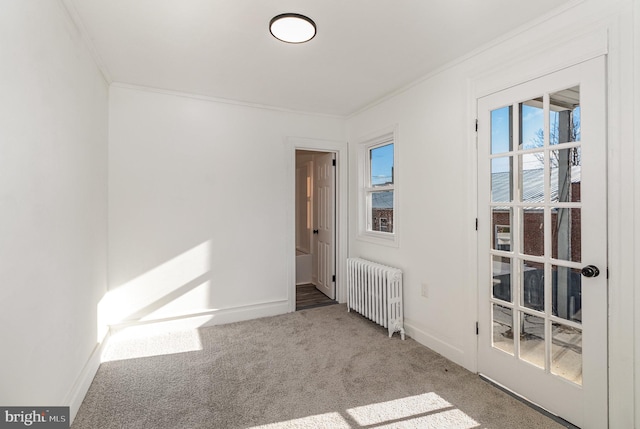 carpeted empty room featuring radiator heating unit and ornamental molding